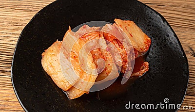 Kimchi Closeup, Kimchee Texture on Black Plate, Red Spicy Kim Chi, Hot Fermented Napa Cabbage Stock Photo