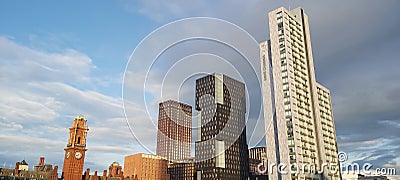Kimpton Clock Tower in Manchester with adjacent skycrapper buildings create a parralel geometric scenery with a sunny sky Stock Photo