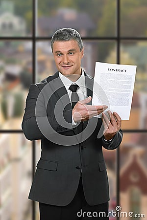 Kind businessman shows employment contract. Stock Photo