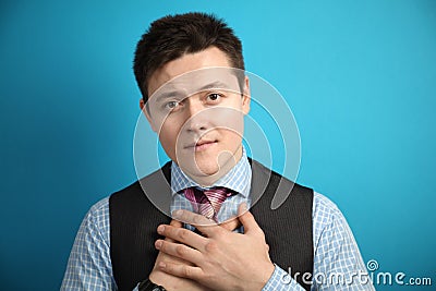 Kind look of a young man in a suit on a blue background. Prayer and redemption of gruhs. Donation Stock Photo