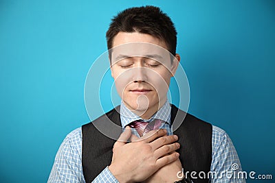 Kind look of a young man in a suit on a blue background. Prayer and redemption of gruhs. Donation Stock Photo