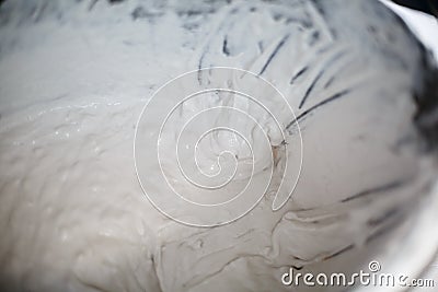 Construction worker with long trowel plastering a wall. Close-up of concrete. Stock Photo