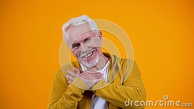 Kind old person crossing palms on breast, smiling to camera, sincerity concept Stock Photo