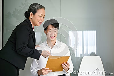 Kind senior Asian businesswoman talks with a candidate in a waiting room Stock Photo