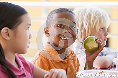 Kindergarten children eating lunch Stock Photo