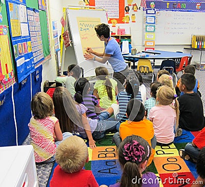 Children studying in a kindergarten classroom with a teacher Editorial Stock Photo