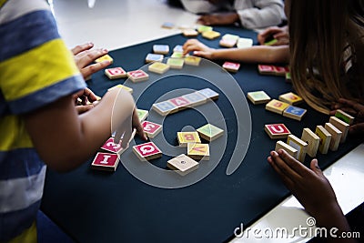 Kindergarten kids playing wooden alphabets letters vocabulary ga Stock Photo