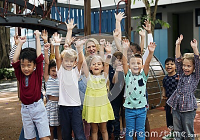 Kindergarten students with arms raised Stock Photo