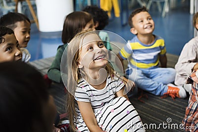 Kindergarten students sitting on the floor Stock Photo