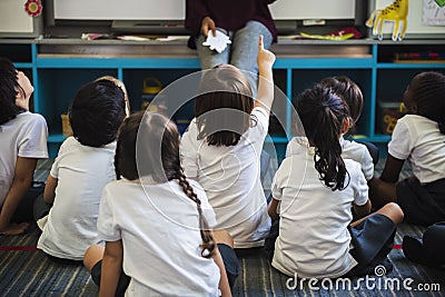 Kindergarten students sitting on the floor Stock Photo