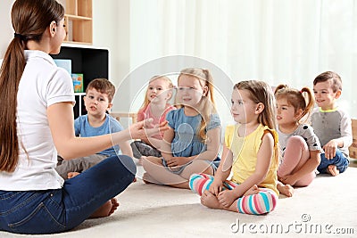 Kindergarten teacher and little children. Learning and playing Stock Photo