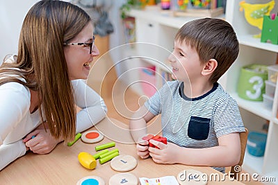 Kindergarten Teacher Supports Cute Boy in Educational Game Play Stock Photo