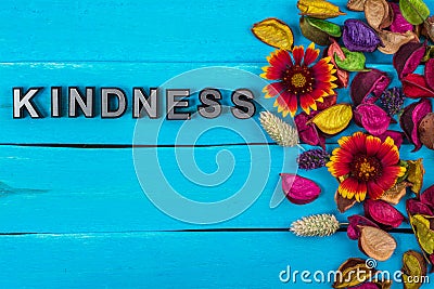 Kindness word on blue wood with flower Stock Photo