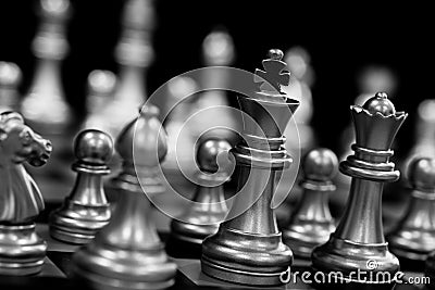 The King in battle chess game stand on chessboard with black isolated background. Business leader concept for market target Stock Photo