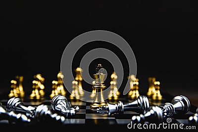 The king golden chess standing in the middle of the falling silver chess. Stock Photo