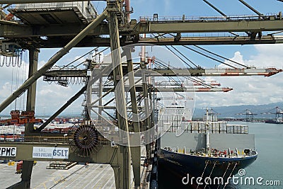 Cargo operation with gantry cranes operated by stevedores of container ship fully loaded with white reefer containers. Editorial Stock Photo