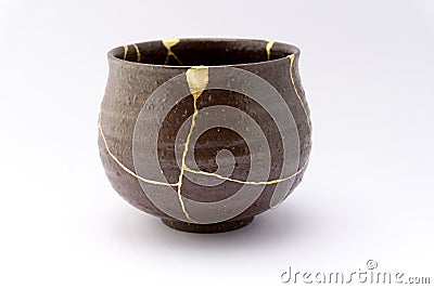 Vintage broken Japanese bowl repaired with gold kintsugi technique Stock Photo