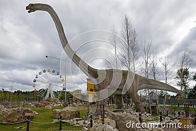 Mamenchisaurus is a herbivorous dinosaur in the childrens paleontologic park `Yurkin Park` in the cloudy afternoon Editorial Stock Photo