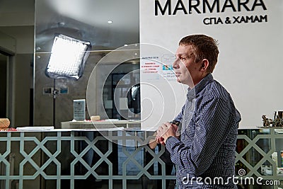 Kirov, Russia - February 25, 2019: Man waiting treatment in spa near reception and nobody near him Editorial Stock Photo