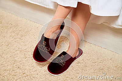 Kirov, Russia - March 16, 2019: Close up crimson slippers on woman`s legs standing on carpet Editorial Stock Photo