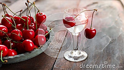 Kirsch or Kirschwasser in a glass and fresh cherry Stock Photo