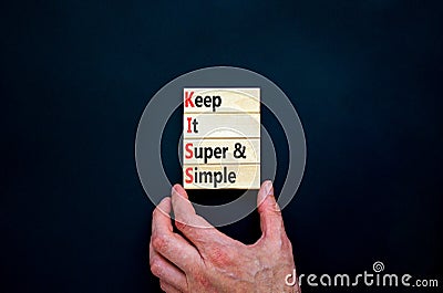 KISS keep it super and simple symbol. Concept words KISS keep it super and simple wooden blocks. Beautiful black table, black Stock Photo