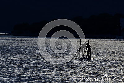 Kiss during sup paddling on moonlight Stock Photo