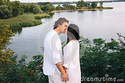 Kissing couple on the river background near the foliage Stock Photo