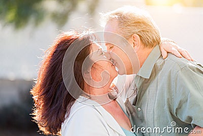 Kissing Middle Aged Couple Enjoy A Romantic Slow Dance and Kiss Outside Stock Photo