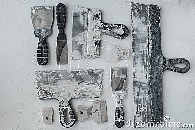 Kit of putty knives. Spatulas with the remaining mortar. Gastarbeiter or guest worker concept. Stock Photo