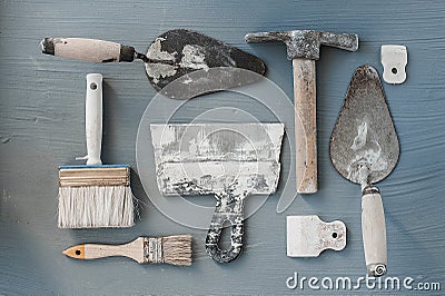 Kit of putty knives. Spatulas with the remaining mortar. Gastarbeiter or guest worker concept. Stock Photo