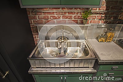 Kitchen cabinet with double steel sink in english style, green table, silver luxury faucet kitchen Stock Photo