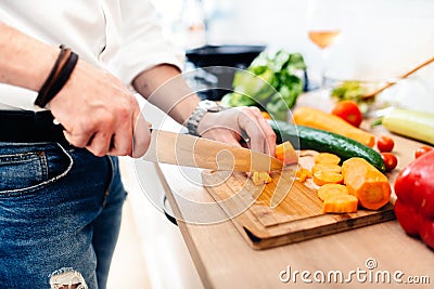 Kitchen chef, master cook preparing dinner. details of knife cutting vegetables in modern kitchen Stock Photo