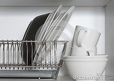 Kitchen cupboard with a lattice for dishes, with a white and black plate, cups, and a drip tray Stock Photo
