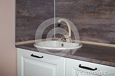 Kitchen furniture with beige sink and brown countertop. Kitchen interier Stock Photo