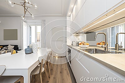 Kitchen with gray furniture with white stone countertop, mirrored wall, Stock Photo