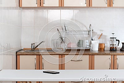 Kitchen interior and mobile phone on table. Forgotten smartphone Stock Photo