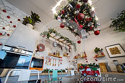 a kitchen island with a hob that reflects the Christmas decoration of the kitchen for the family Christmas celebration Editorial Stock Photo