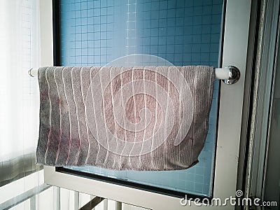 Kitchen microfiber cloth drying at the window mounted aluminium and pvc pipe towel rack. Home DIY project hack to the window Stock Photo