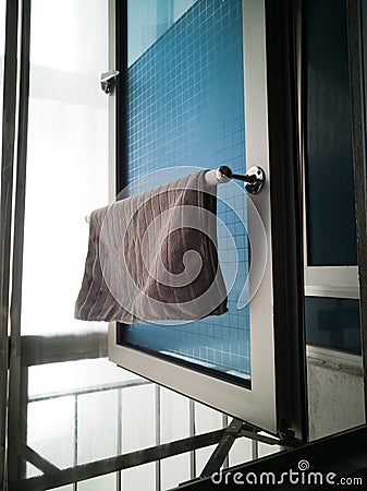 Kitchen microfiber cloth drying at the window mounted aluminium and pvc pipe towel rack. Home DIY project hack to the window Stock Photo