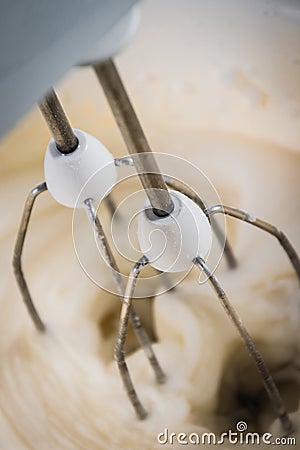 A kitchen mixer mixing sugar and water to form sweet icing for a Stock Photo