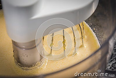 A kitchen mixer with yellow egg yolks mixed with sugar in a mode Stock Photo