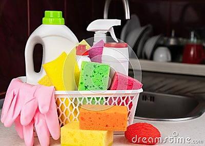 Kitchen sponges, various detergents, cleaners products and rubber gloves in the basket on the table at the kitchen. Cleaning Stock Photo