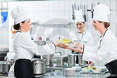 Kitchen staff in canteen preparing dishes Stock Photo