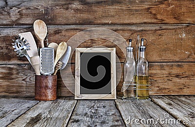 Kitchen still life. Kitchen utensils in a stand near the wooden wall.Kitchen tools, wooden frame with free space for text on a kit Stock Photo