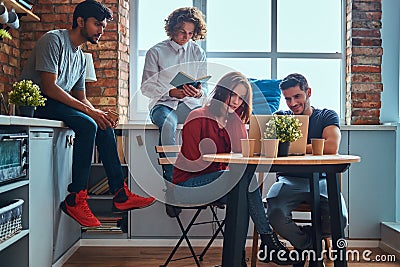 Kitchen in student dormitory. Group of interracial students engaged in education. Stock Photo