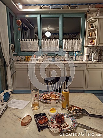 Kitchen table with dinner leftovers eaten by a lonely person during the coronavirus lookdown Editorial Stock Photo