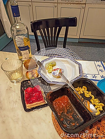 Kitchen table with dinner leftovers eaten by a lonely person during the coronavirus lookdown Editorial Stock Photo