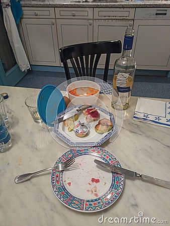 Kitchen table with dinner leftovers eaten by a lonely person during the coronavirus lookdown Editorial Stock Photo