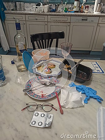 Kitchen table with dinner leftovers eaten by a lonely person during the coronavirus lookdown Editorial Stock Photo